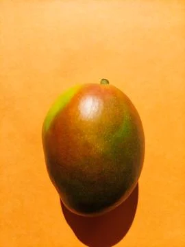 Single Ripe Mango on an Orange Background Stock Photos