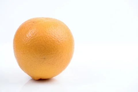 A single ripe orange fruit displayed on a clean white background with subtl.. Stock Photos