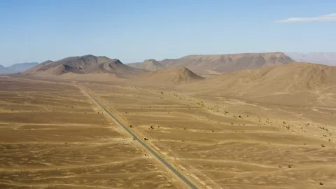 A single road bisects an endless swath of vividly colored desert Stock Footage 127025395