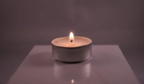 A single romantic tea light burning, romatic and love concept Stock Photos