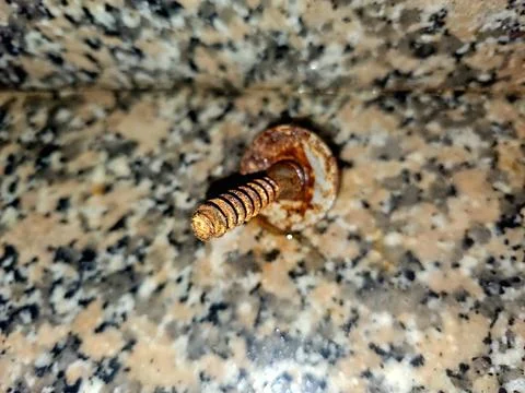 A single, rusted screw with a damaged head and stripped threads Stock Photos