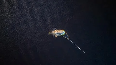Single Sailboat Floating in Deep Blue Water Aerial Top View Stock Photos
