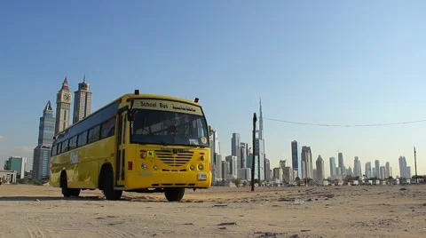 Single school bus stand at vacant sandy plot against Dubai towers on back Vídeos de archivo 67979940