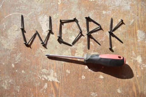 Single screwdriver under the word work made of screws Stock Photos