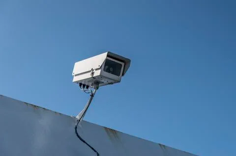 Single security camera, against a deep blue sky. Stock Photos