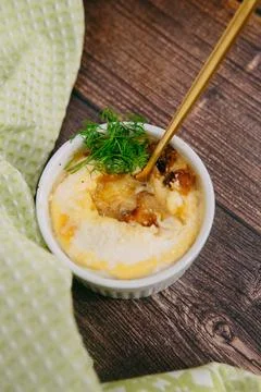Single serving baked egg dish in baking cup, decorated with dill in a warm color Stock Photos