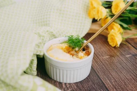 Single serving baked egg dish in baking cup, decorated with dill in a warm color Stock Photos