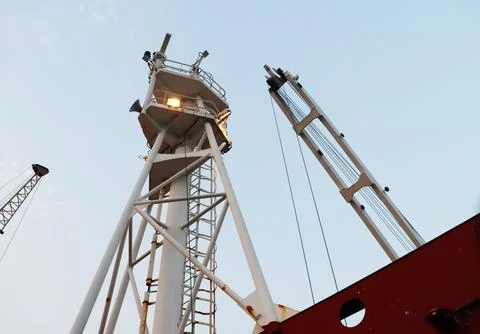 Single ship crane and light stand in the blue sky view. Stock Photos