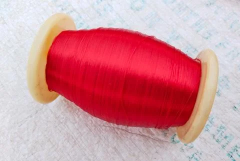 Single silk thread spool on plastic carpet. Stock Photos