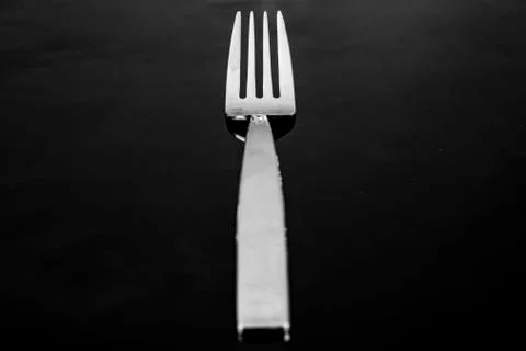 Single silver fork placed on a black background individually Stock Photos