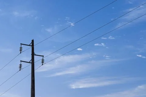 A single, simple utility pole with three power lines and insulators, set agai Stock Photos