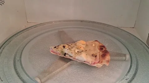 Single slice of cheesy pizza rotating inside microwave motion footage Stock Footage 337896981