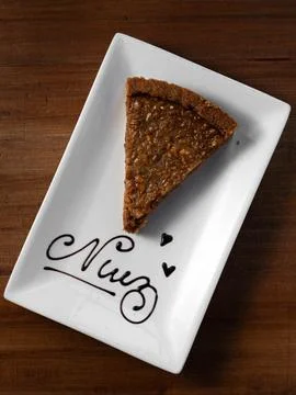 Single slice of chocolate tart rests on a white plate Stock Photos