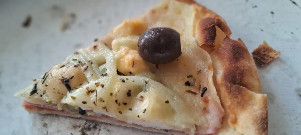 Single slice of delicious melted cheese pizza with black olive Fotos de archivo