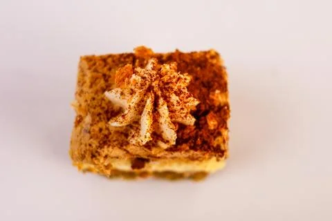 Single slice of layered sponge cake topped with a swirl of whipped cream dusted Stock Photos