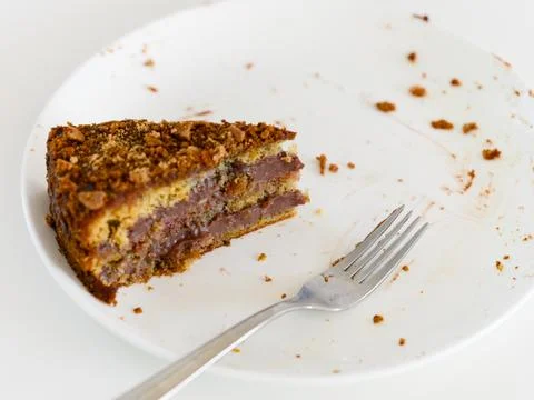 A single slice of multi-layered gluten-free and lactose-free cake remaining o Stock Photos