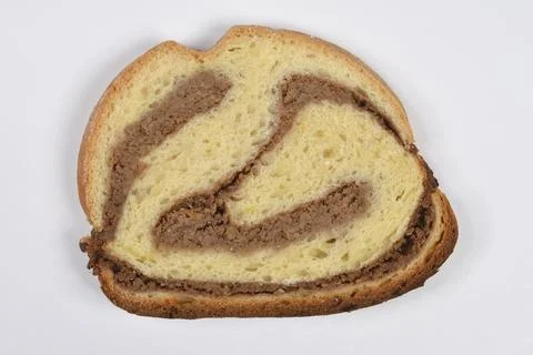 Single slice of traditional walnut roll on white background Foto stock