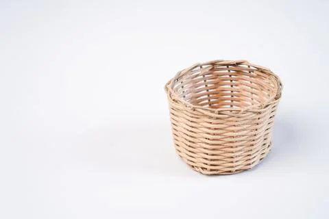 A single small empty woven wicker basket placed on the right side of a plai.. Stock Photos
