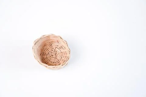 A single small empty woven wicker basket placed on the left side of a plain.. Stock Photos