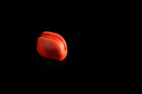 Single small red oval-shaped chocolate candy with decoration Stock-Fotos