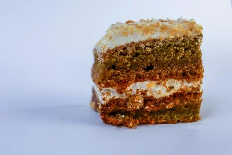 Single small square of nut and sponge layered cake sprinkled with glistening Stock Photos