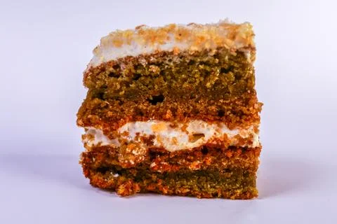 Single small square of nut and sponge layered cake sprinkled with glistening Stock Photos