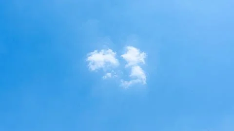 Single small white fluffy cloud centered in a clear blue daytime sky blue sky Stock-Fotos