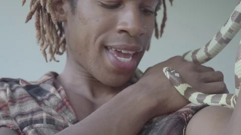 Single smiling man holding and lifting light brown colored snake with his hand Stock-Footage 126054383