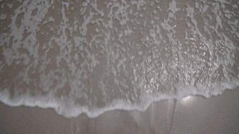 Single, Smooth Surf on Wet Sand, Sun Reflecting 03 Stock Footage 104746297