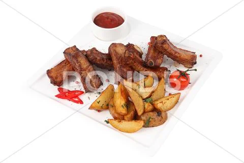 Single spareribs with potato sliced on white square serving dish. Stock Photos