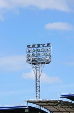 Single spot-light pole with blue sky in stadium Stock Photos