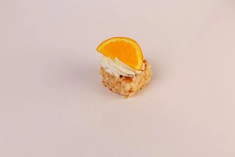 Single square piece of vanilla sponge cake layered with whipped cream and artful Stock Photos