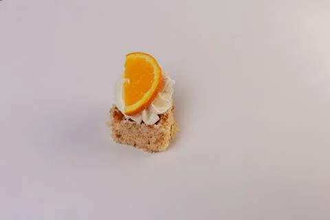 Single square piece of vanilla sponge cake layered with whipped cream and artful Stock Photos