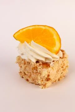 Single square piece of vanilla sponge cake layered with whipped cream and artful Stock Photos