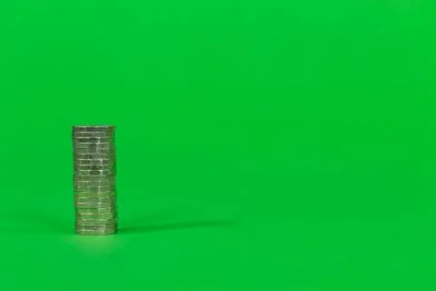 Single Stack of UK Cash Pound Coins on a Bright Green Background 写真素材