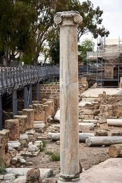 A single stone column standing among the ruins of ancient buildings Stock Photos