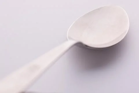 Single table spoon from different perspective on white Foto stock