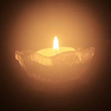Single tea light candle in the dark Stock Photos