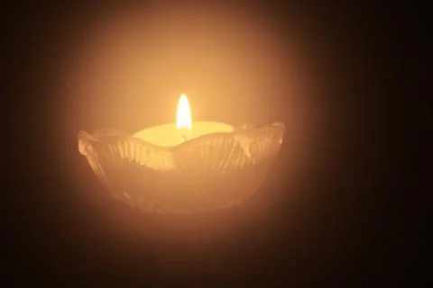 Single tea light candle in the dark Stock Photos