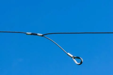 Single thin metal cable loop hanging on sky Foto stock