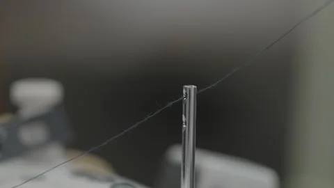 Single Thread Tension Pin on Industrial Sewing Machine Against Dark Background Stock Footage 332948813