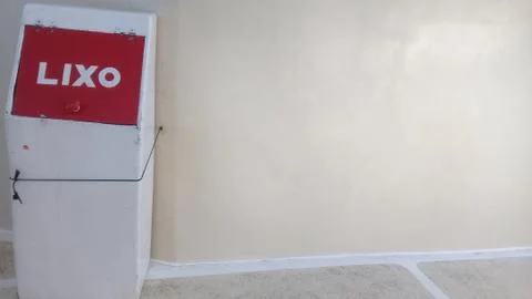 A single tin trash can close to the wall with red cap Stock Photos