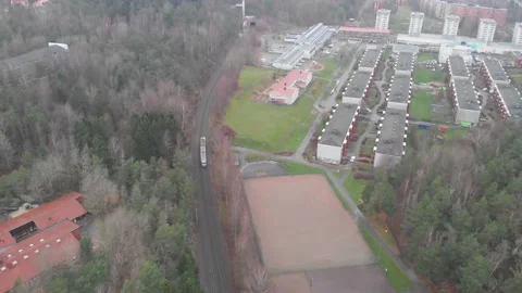 Single Tram Running Through the Suburb Area With Apartments and Forest, Aerial Stock Footage 147140032