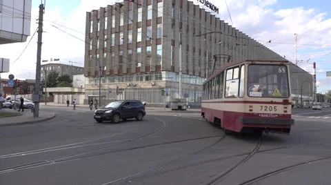 Single tram turns left in front of a Soviet style industrial building Stock Footage 67468116