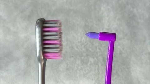 Single tuft brush and a toothbrush on a gray background Stock Footage 313356260