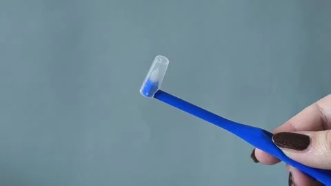 Single Tuft Toothbrush With Cap On Grey Background Close-Up Vidéo 329969520