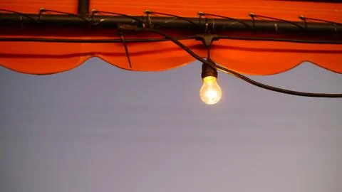 Single Tungsten Hanging from Store Front Stock Photos
