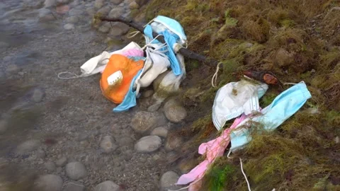 SIngle use face masks and latex gloves have started polluting water Stock Footage 133218515