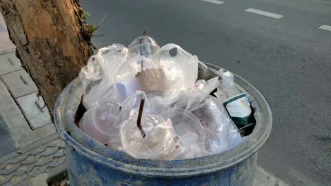Single Use Plastic Beverage Cups With Straws and Plastic Bags in Garbage Bin Stock Footage 130771376