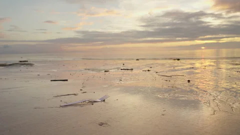 Single-use plastic fork on sand at beach, ocean pollution Stock Footage 336491700